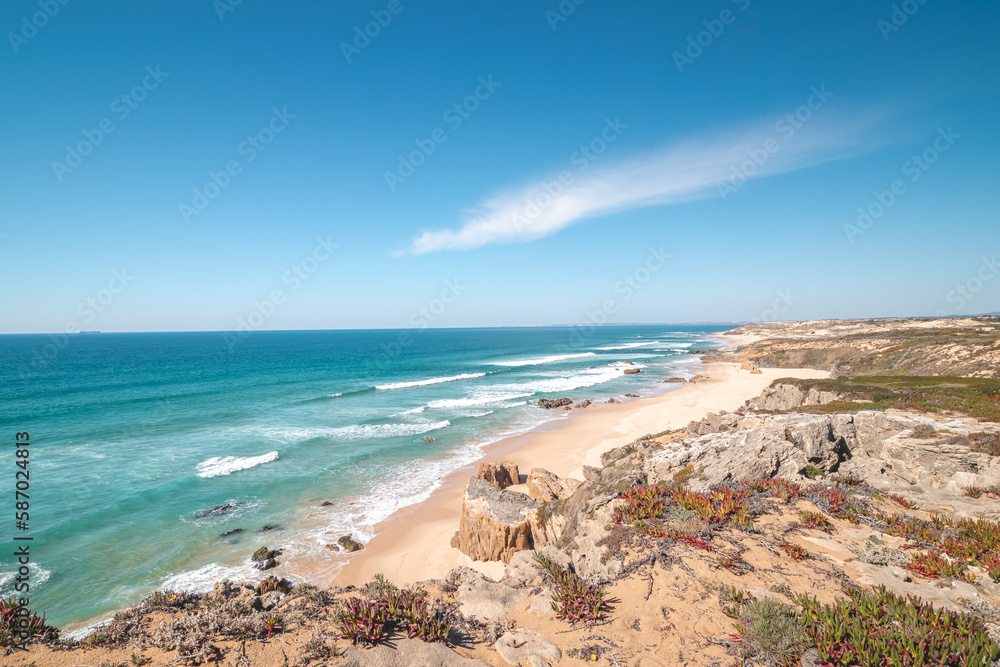 Rocks surround the sandy beach of Praia do Malhao Sul on the Atlantic coast near Vila Nova de Milfontes, Odemira, Portugal. In the footsteps of Rota Vicentina. Fisherman trail