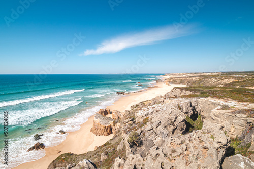 Rocks surround the sandy beach of Praia do Malhao Sul on the Atlantic coast near Vila Nova de Milfontes, Odemira, Portugal. In the footsteps of Rota Vicentina. Fisherman trail photo