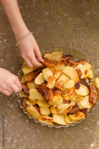 Children take fried potatoes with their hands photo