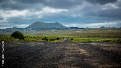 View on green Lanzarote vocanic landscape with rain clouds photo