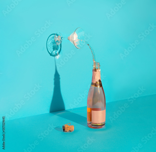 Concept art with Champagne bottle and glass. Minimal art direction with a party or celebration theme.
