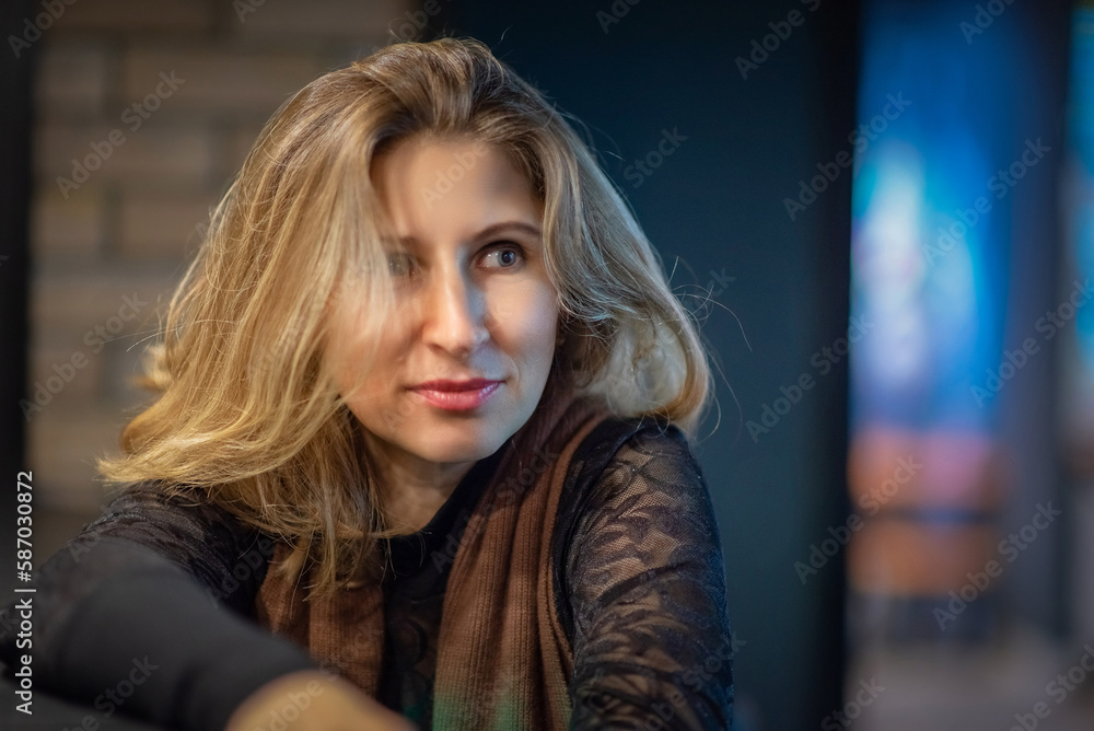 Fototapeta premium Portrait of a young beautiful fair-haired girl in the studio under artificial lighting.