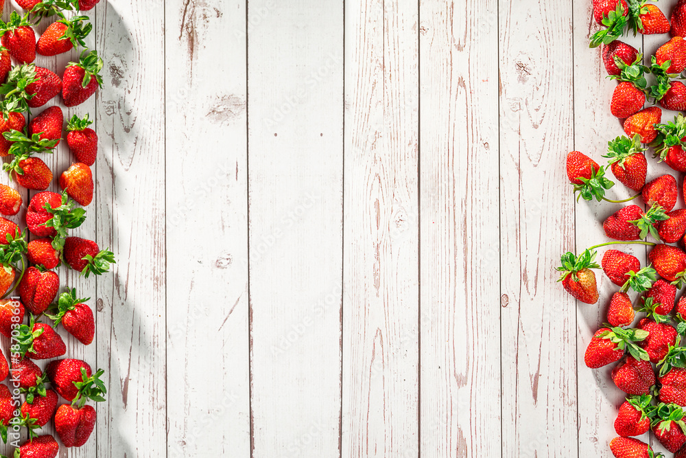 Strawberries on rustic white wooden table. Berry harvest in summer. Fresh raw red fruits with green leaves Strawberries on rustic white wooden table. Berry harvest in summer. Fresh raw red fruits with green leaves