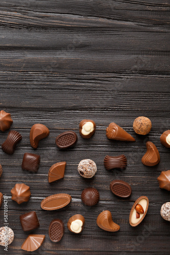Assorted chocolates on dark wooden background top view