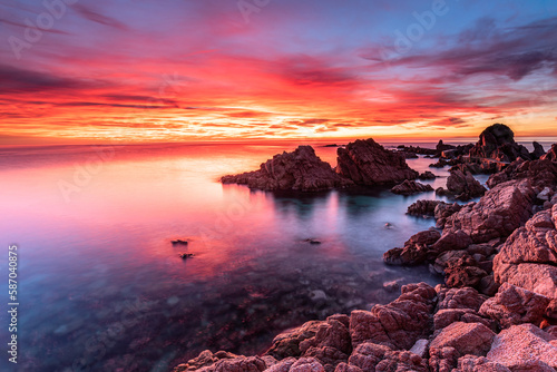 Red sky at sunrise on the rocky coastline