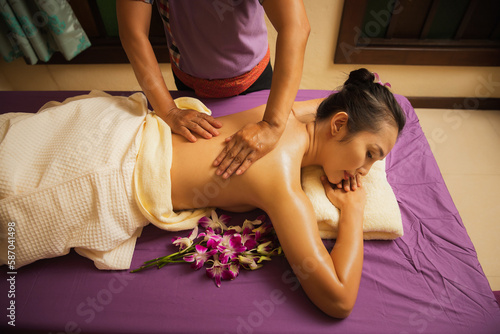 Fotografija Asian woman enjoying back massage in massage salon