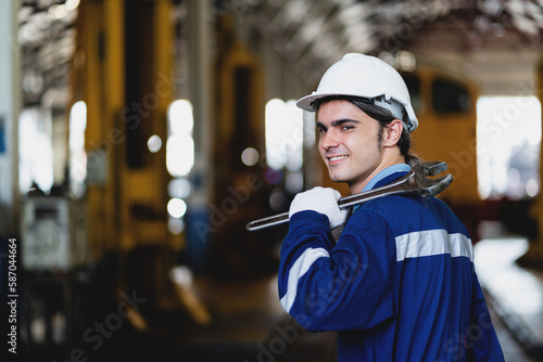 Worker or male mechanic standing confidently holding wrench in industrial factory. Occupation repair and maintenance Service after vehicle damage check.