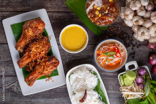 Deep fried chicken with Rice noodles with fish coconut milk curry sauce and spicy curry sauce, southern style with vegetables set, boiled egg and pickled vegetables, Thai traditional style.