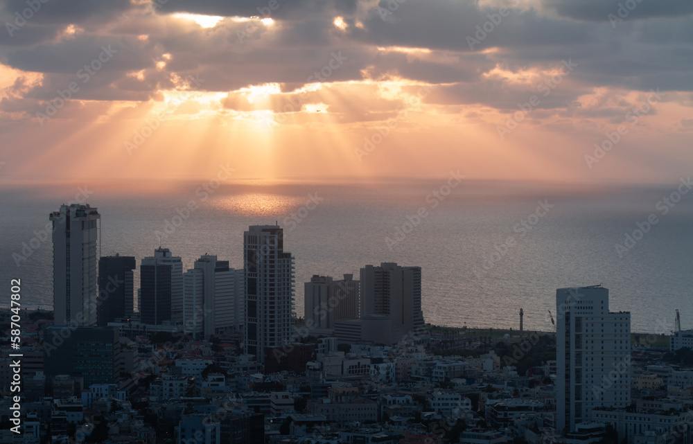 Tel Aviv sunset view. Sunrays on the sea, high-rise buildings