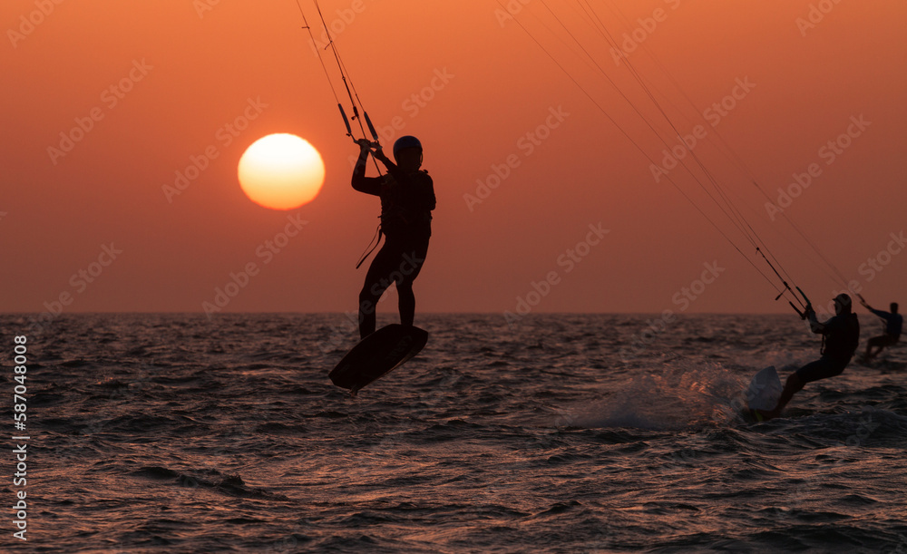 People ride a Kiteboarding during the sunset. Mediterranean sea, Israel