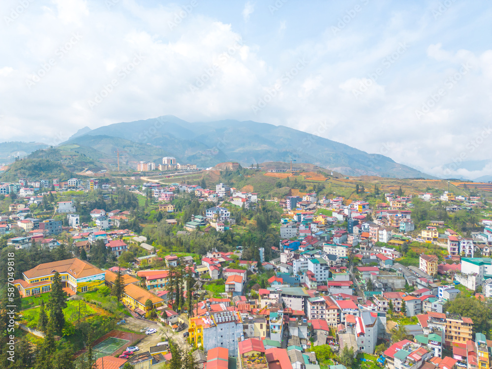 Fototapeta premium Aerial view of landscape at the hill town in Sapa city, Lao Cai Province, Vietnam in Asia with the sunny light and sunset, mountain view in the clouds