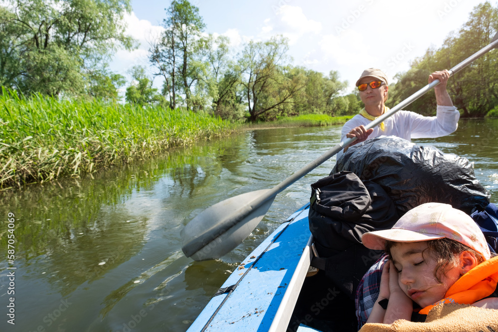 Family kayak trip. Father and daughter rowing boat on the river, a water hike, a summer adventure. Eco-friendly and extreme tourism, active and healthy lifestyle Family kayak trip. Father and daughter rowing boat on the river, a water hike, a summer adventure. Eco-friendly and extreme tourism, active and healthy lifestyle
