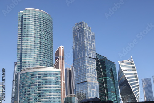 View of the office buildings of the Moscow City business center, skyscrapers, luxury apartments through green trees. Panorama of Moscow skyscrapers, March 2023.
