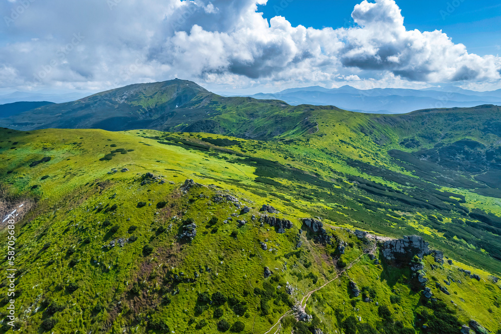 Fototapeta premium Aerial view of beautiful mountain forest covered with fluffy clouds.