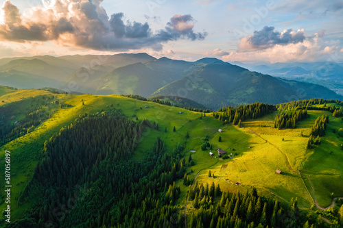 Aerial view of beautiful mountain forest covered with fluffy clouds.