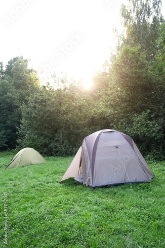 Installed tourist tent in a camping in nature in the forest. Domestic tourism, active summer holidays, family adventures. Ecotourism, sport, hike. mock up