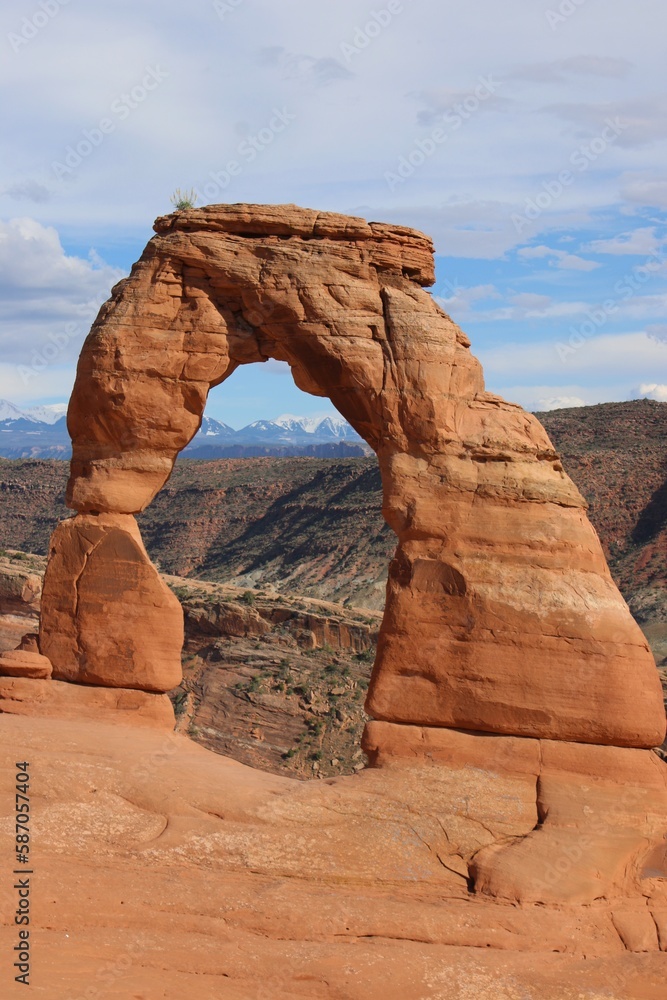 Delicate Arch in Utah desert with Mountains behind Delicate Arch in Utah desert with Mountains behind