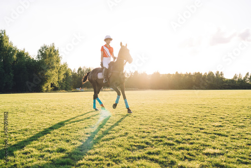 Female equestrian riding horse in field © BullRun