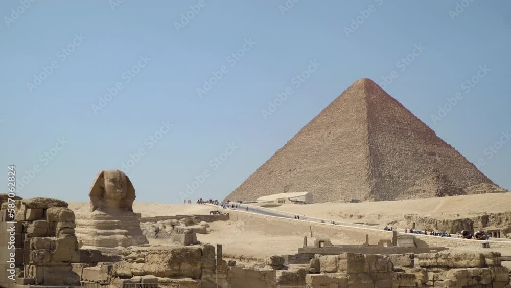 Giza Pyramids and the stone Sphinx on the Giza platou in Sahara desert - the Greatest wonder of the world as part of ancient Egypt in Cairo Giza Pyramids and the stone Sphinx on the Giza platou in Sahara desert - the Greatest wonder of the world as part of ancient Egypt in Cairo
