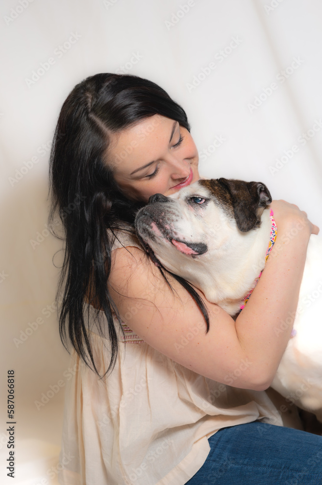 Sweet image of woman kissing bulldog on white background. End of life tribute prior to euthanasia. Sweet image of woman kissing bulldog on white background. End of life tribute prior to euthanasia.
