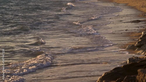 Sandy seashore with small waves in the evening at Sunset in Cadiz Spain.