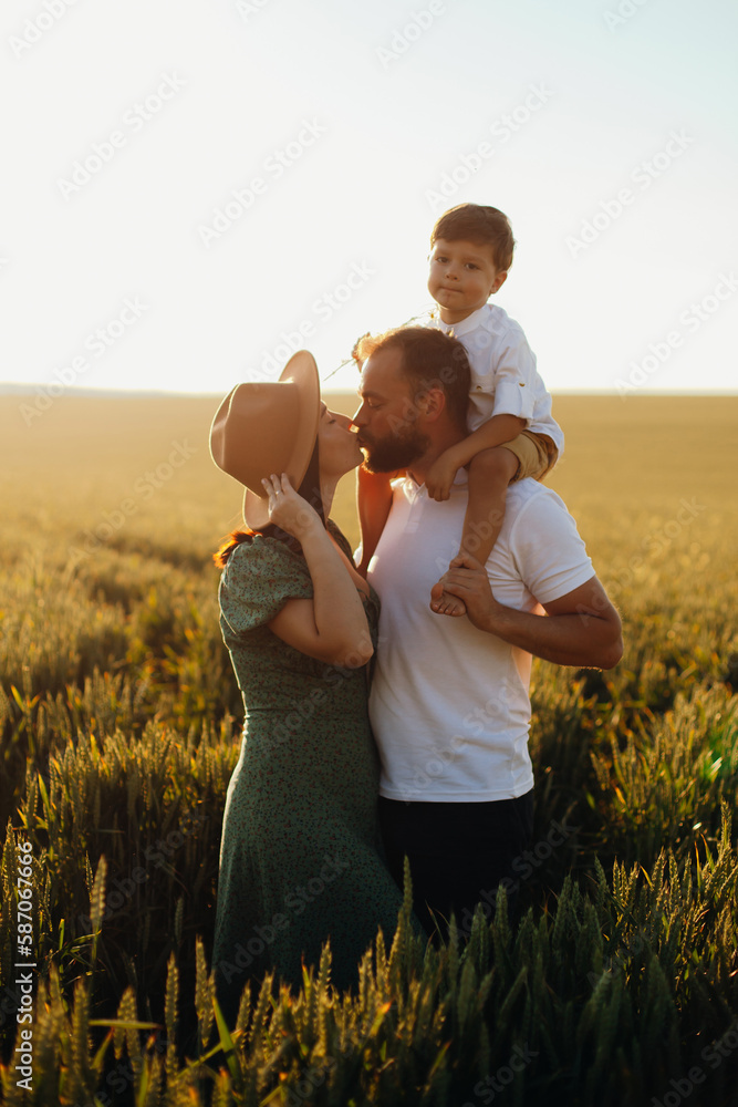 Happy family father and mother and child son walking on nature at sunset