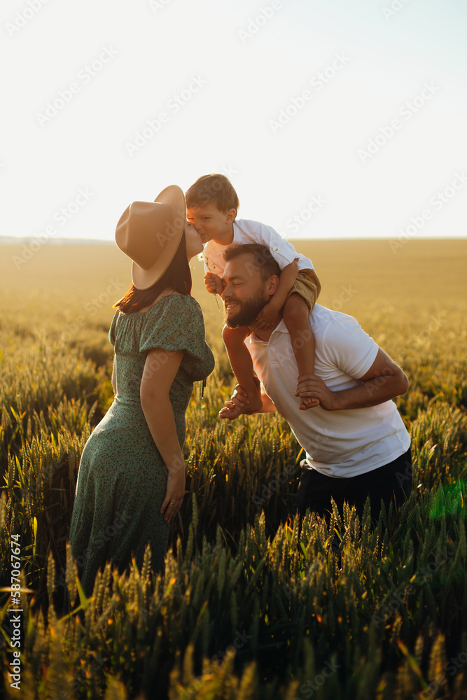 Happy family father and mother and child son walking on nature at sunset