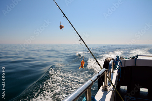 A spinning rod for catching fish with shrimp bait is rigged on board the fishing boat.