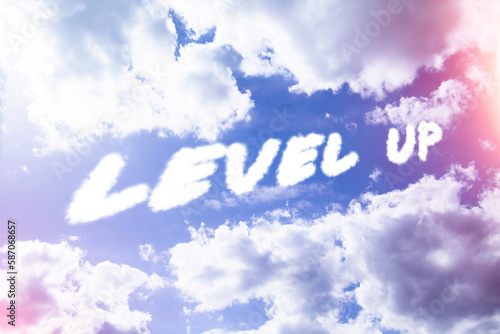 Level up. Text from clouds in sky in bright sunlight.