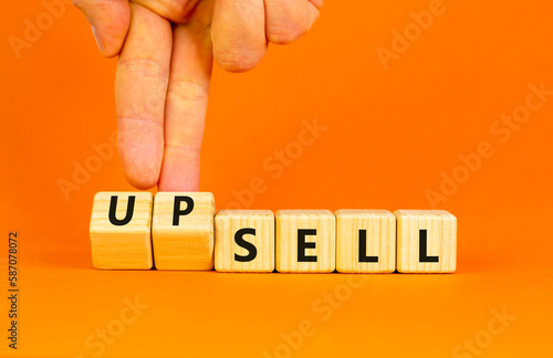 Sell or upsell symbol. Concept word Sell Upsell on wooden cubes. Businessman hand. Beautiful orange table orange background. Business Sell or Upsell concept. Copy space. photo