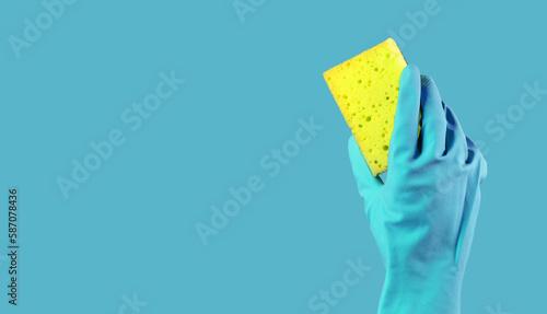 Yellow washing sponge in hand in blue glove on background, promotion banner design for professional cleaning service