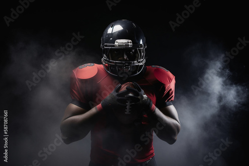 American football player on a dark background in smoke in black and red equipment