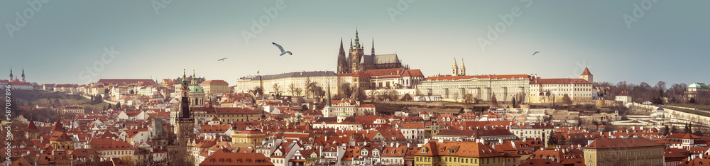 Obraz premium Panorama of Prague Castle with Gothic Cathedral of st.Vitus on skyline. Wide city landscape of Praga, view on Petrin Hill, Hradcany area and buildings with red tiles roofs. Banner for travel agency.