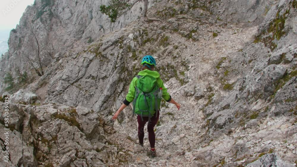 Woman climber with a backpack and a helmet in the mountains. adventure and mountaineering concept. hiking with a backpack in the mountains. mountains of Turkey. Woman climber with a backpack and a helmet in the mountains. adventure and mountaineering concept. hiking with a backpack in the mountains. mountains of Turkey.