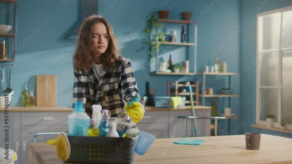 An Angry and Tired Young Woman Wear Yellow Protective Rubber Gloves , Holding a Spray Bottle and Cleaning a Table in the Kitchen. Multi-functional Cleaning Tools. Cleaning for Mental Clarity and Focus An Angry and Tired Young Woman Wear Yellow Protective Rubber Gloves , Holding a Spray Bottle and Cleaning a Table in the Kitchen. Multi-functional Cleaning Tools. Cleaning for Mental Clarity and Focus
