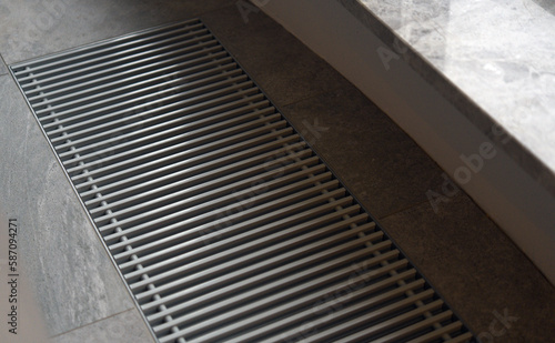 Heating grill with ventilation in the floor in laminate.. Forced hot-air heating systems are extremely popular and feature vents like this to channel the hot air throughout the house.