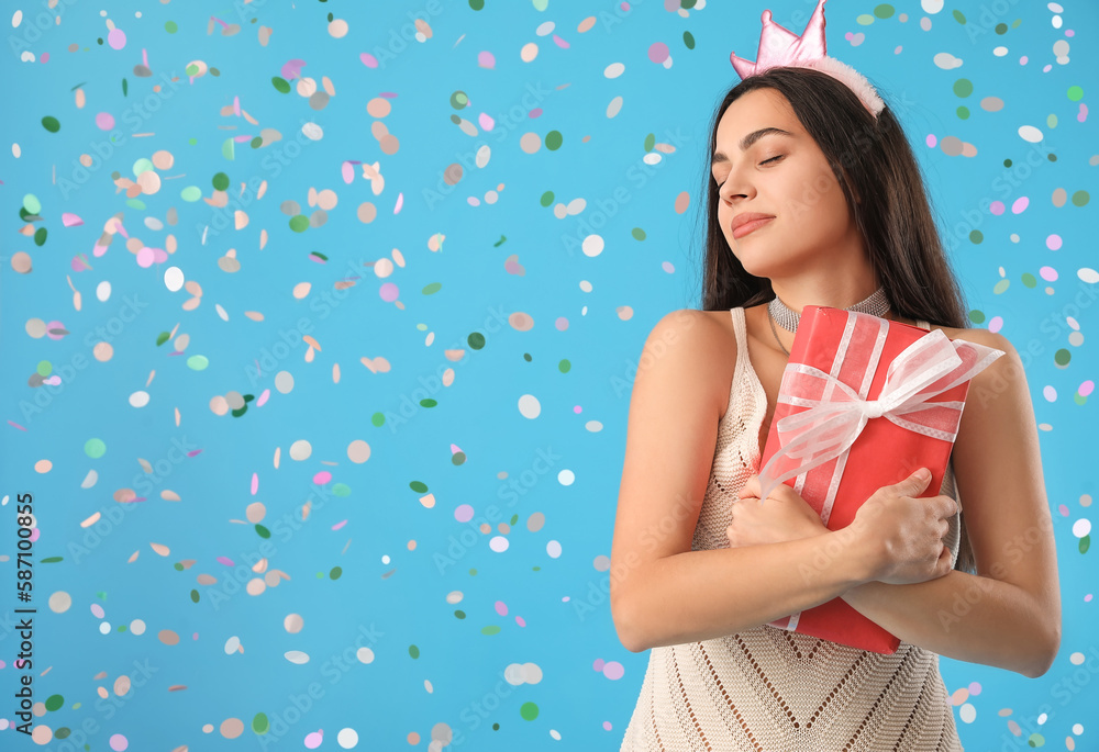 Happy young woman with Birthday gift on blue background Happy young woman with Birthday gift on blue background