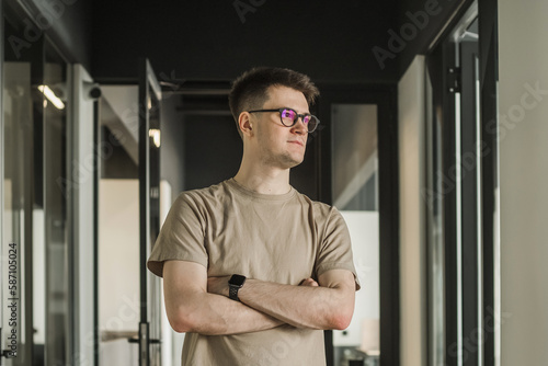 Headshot portrait smart businessman in glasses sitting at work desk in modern office, looking at camera, confident satisfied student freelancer posing for photo at workplace