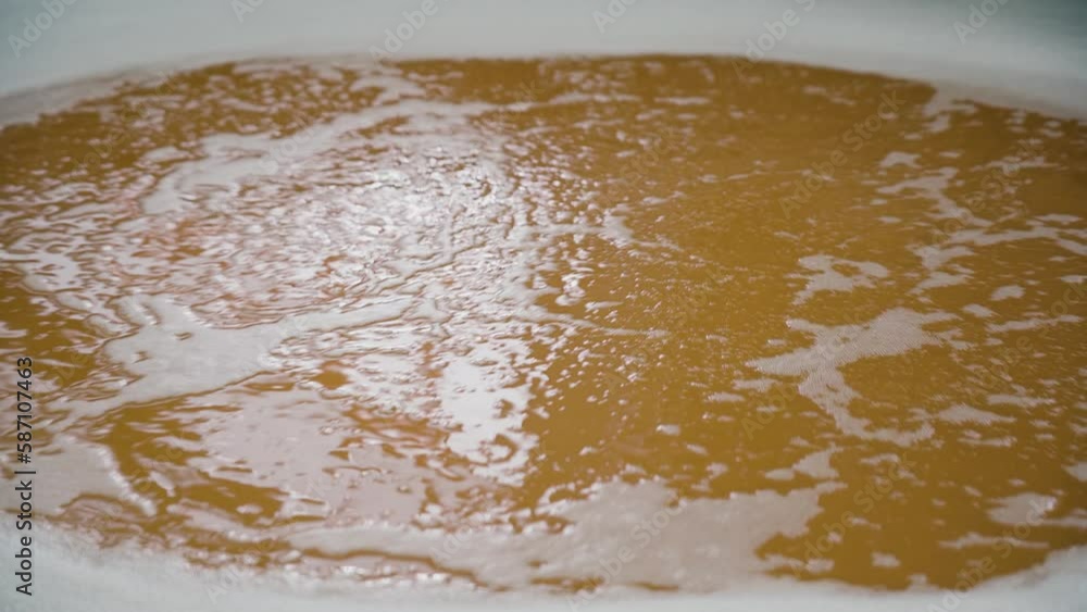 Beer in the huge steel tank for brewing whirls.Beer in a whirlpool, mixed.Brewing,beer factory. Beer in the huge steel tank for brewing whirls.Beer in a whirlpool, mixed.Brewing,beer factory.