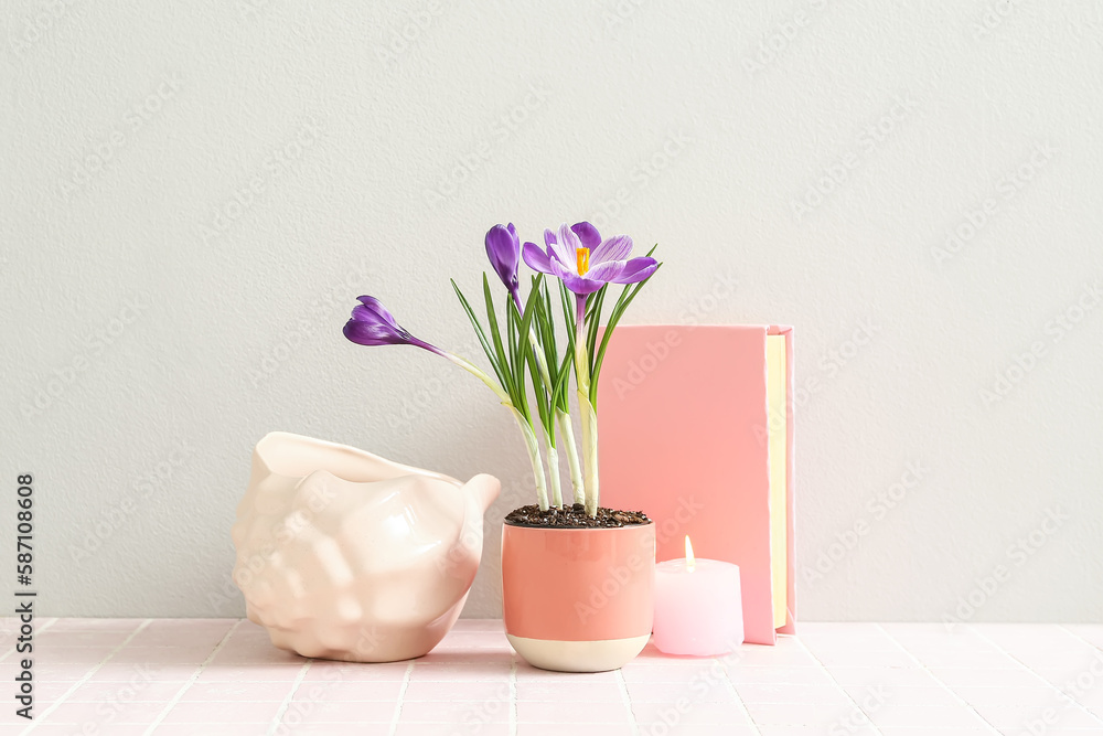 custom made wallpaper toronto digitalPot with beautiful crocus flowers, decorative seashell, book and burning candle on table near white wall