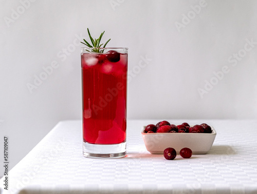 Cranberry juice in a glass on a table with a white tablecloth