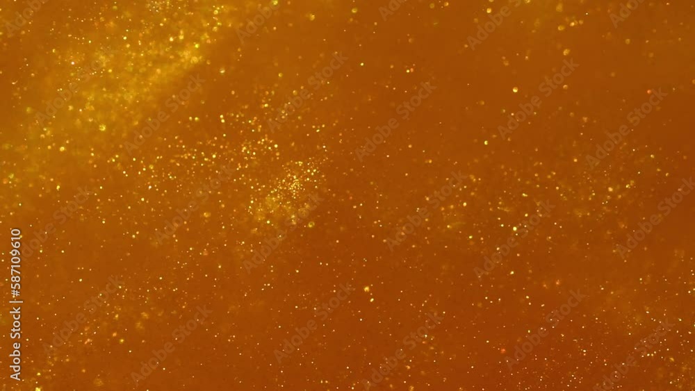 Slow Motion Of Flying Gold Particles. Beautiful abstract movement of gold glittering dust in liquid with depth of field. Gorgeous and glittering gold particles sparkling background. Slow Motion Of Flying Gold Particles. Beautiful abstract movement of gold glittering dust in liquid with depth of field. Gorgeous and glittering gold particles sparkling background.