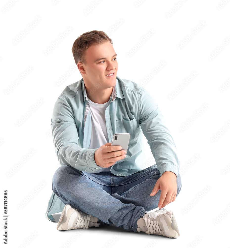 Young man with smartphone sitting on white background Young man with smartphone sitting on white background
