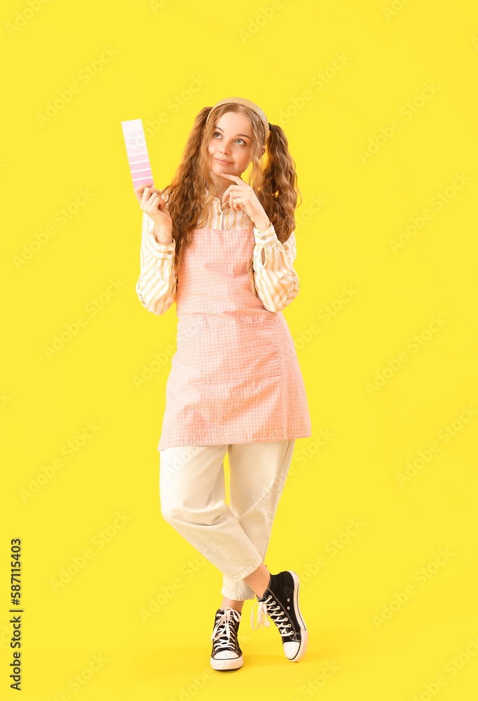 Thoughtful female artist with paint color palette on yellow background Thoughtful female artist with paint color palette on yellow background