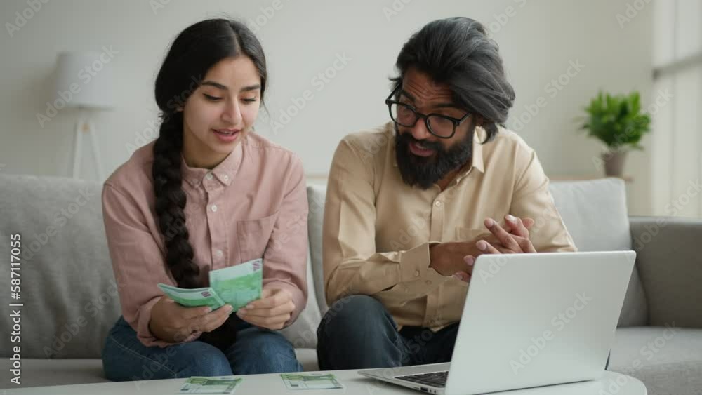Wife and husband planning budget arabian muslim couple count money at home distribute currency two piles rich woman man counting euro banknotes cash on table with laptop online paying bank loan credit Wife and husband planning budget arabian muslim couple count money at home distribute currency two piles rich woman man counting euro banknotes cash on table with laptop online paying bank loan credit