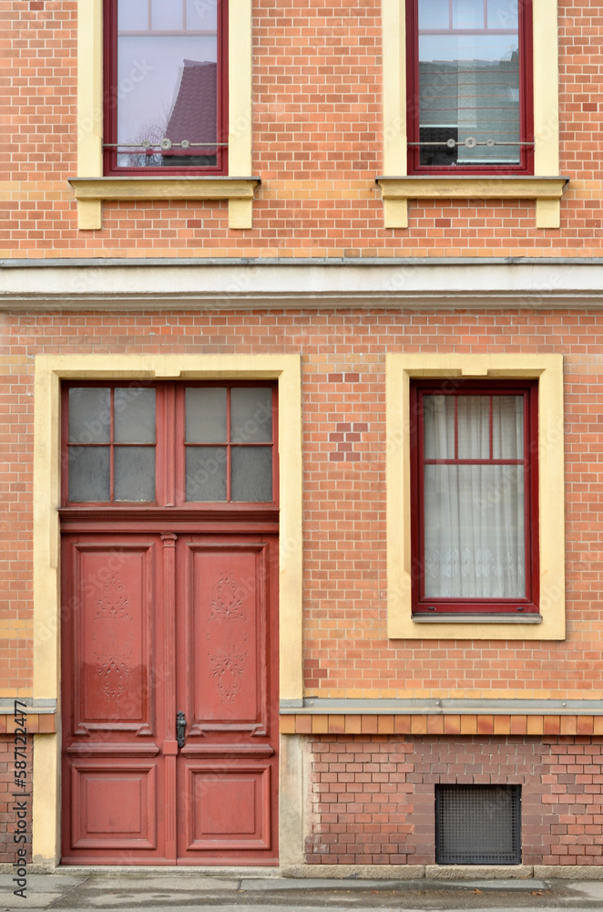 View of brick building with red door and windows View of brick building with red door and windows