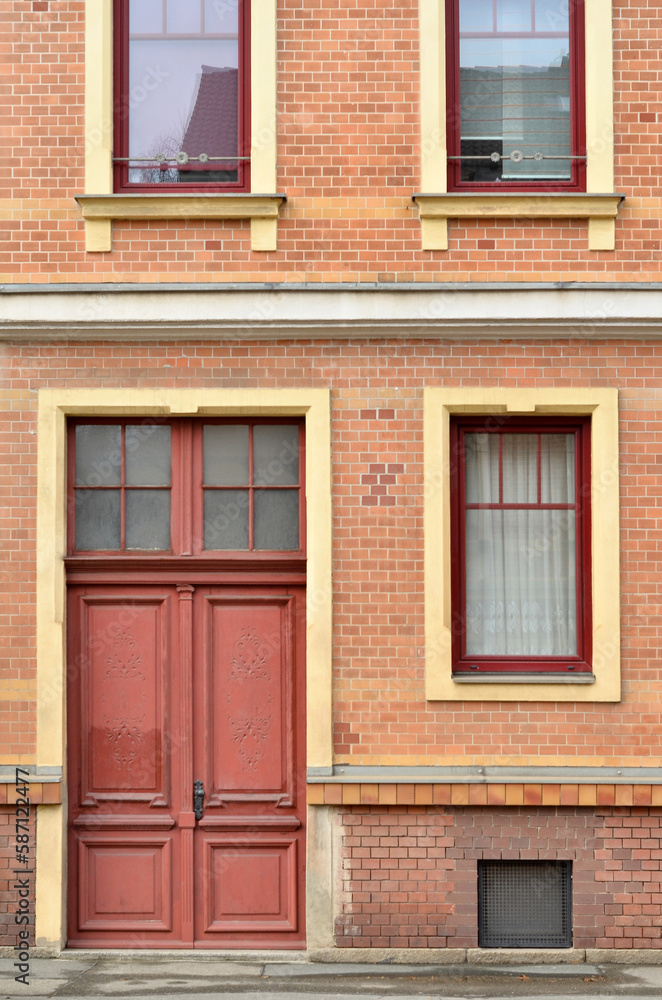 View of brick building with red door and windows