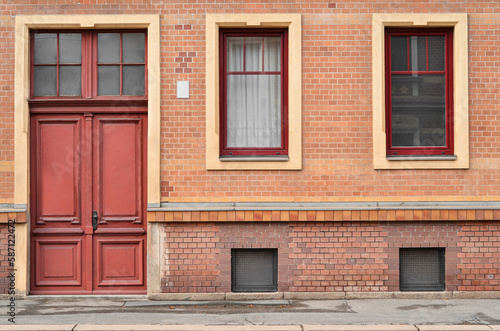 View of brick building with red door and windows