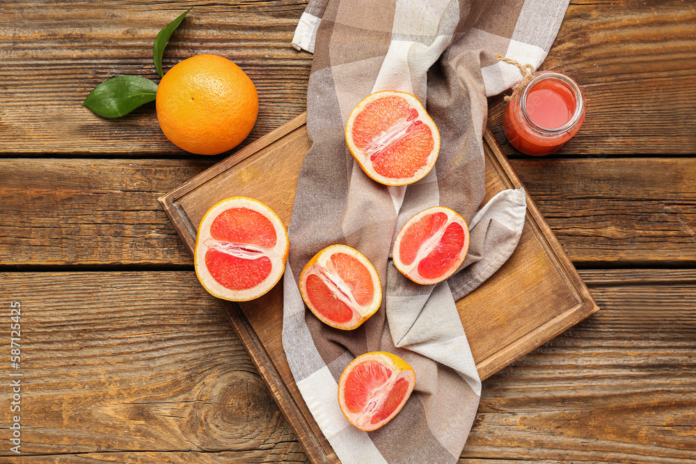 Board with cut grapefruits and bottle of juice on wooden background Board with cut grapefruits and bottle of juice on wooden background