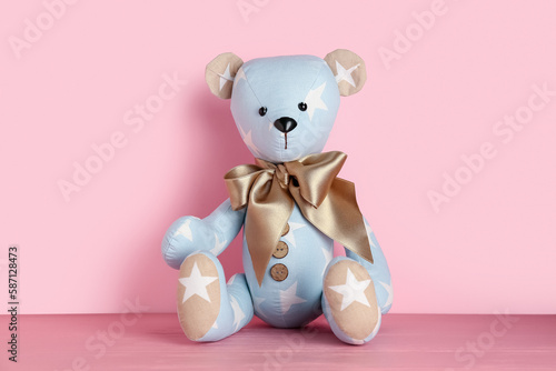 Toy bear on table near pink wall